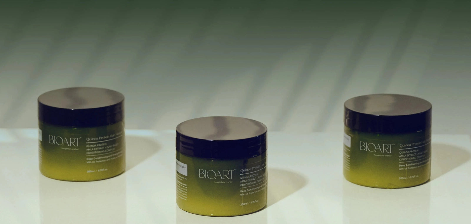 Three jars of Biorit cream on a reflective surface with a gradient background