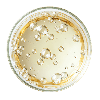 Top-down view of a glass with a yellow liquid and bubbles on a dark background