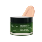 Green jar of BIOART Ultra Radiance Moisturizer with a hand applying cream on a white background